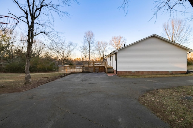 property exterior at dusk with a wooden deck