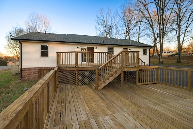 back house at dusk with a wooden deck