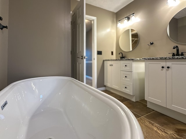 bathroom featuring vanity, tile patterned floors, and a tub