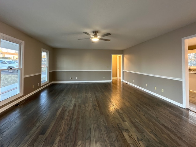 empty room with dark hardwood / wood-style flooring and ceiling fan