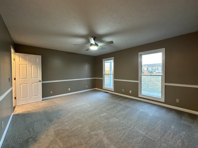 unfurnished room featuring a textured ceiling, carpet floors, and ceiling fan