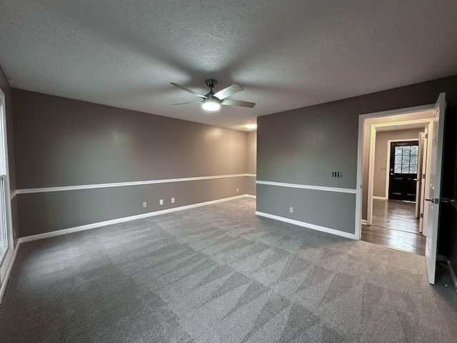 carpeted spare room with ceiling fan and a textured ceiling