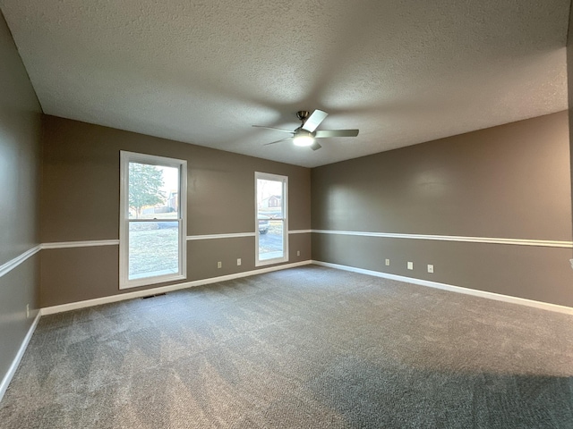 carpeted empty room featuring ceiling fan and a textured ceiling