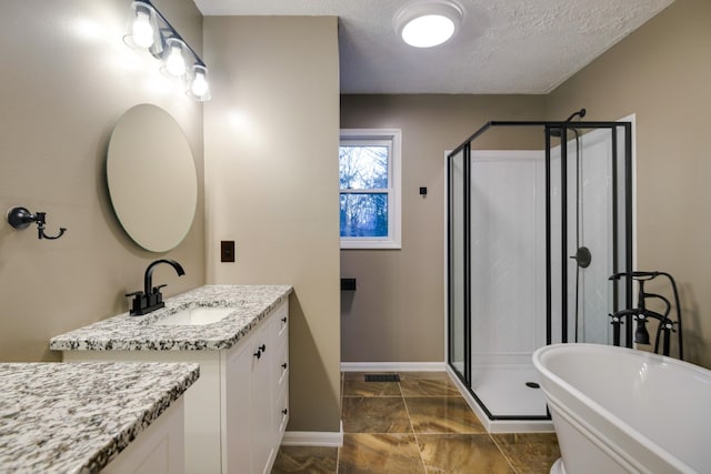 bathroom featuring vanity, a textured ceiling, and separate shower and tub