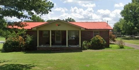 back of property with a yard and covered porch