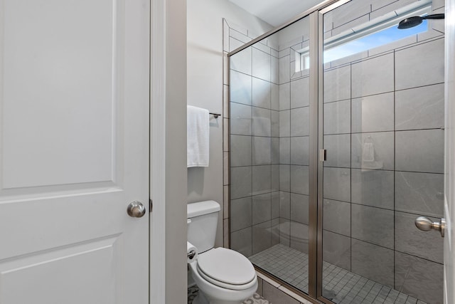 bathroom with a shower with shower door and toilet