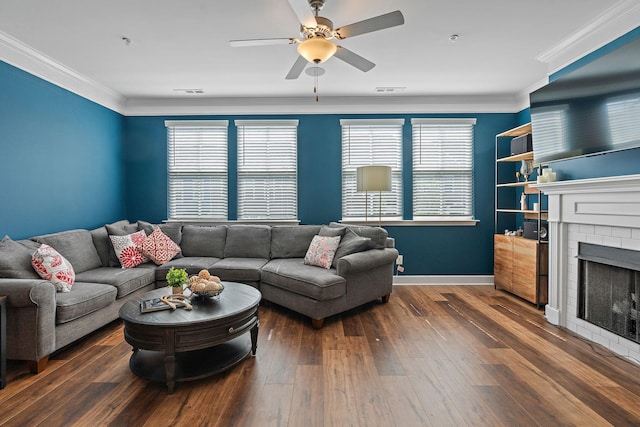 living room with a brick fireplace, crown molding, dark hardwood / wood-style floors, and a healthy amount of sunlight