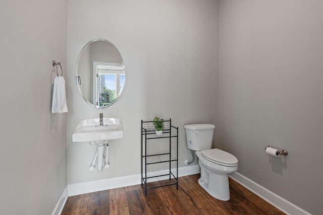 bathroom featuring hardwood / wood-style flooring, sink, and toilet