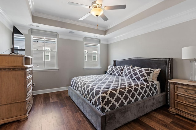 bedroom with a tray ceiling, ornamental molding, dark hardwood / wood-style floors, and ceiling fan