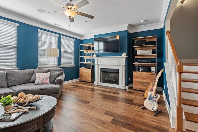 living room featuring hardwood / wood-style flooring, ornamental molding, a fireplace, and ceiling fan