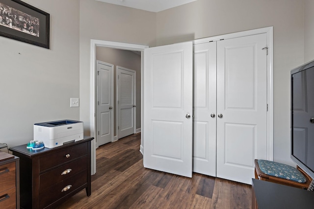 bedroom with dark wood-type flooring and a closet