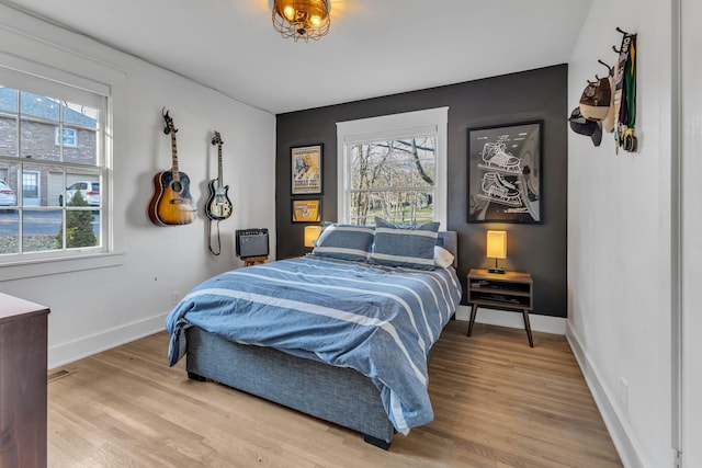 bedroom featuring multiple windows and hardwood / wood-style flooring