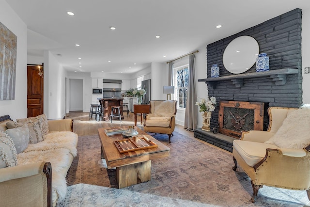 living room featuring a stone fireplace and light hardwood / wood-style floors