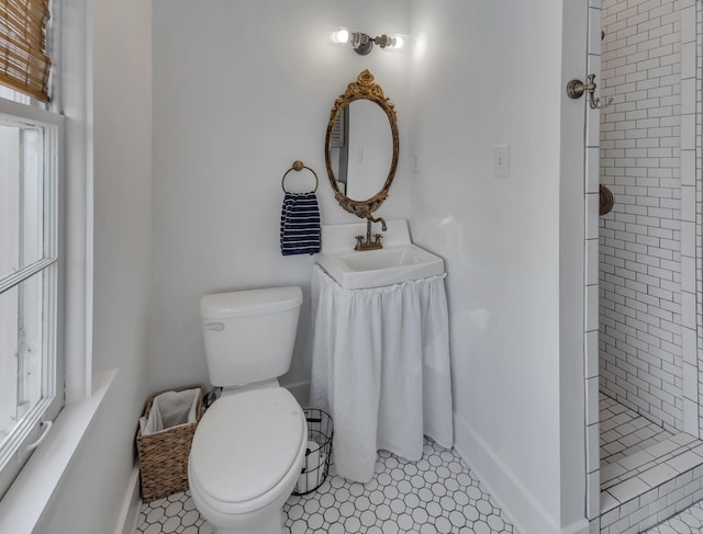 bathroom with vanity, tiled shower, and toilet