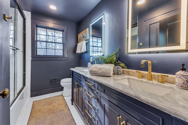 full bathroom featuring enclosed tub / shower combo, vanity, and toilet