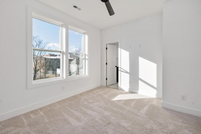 empty room featuring ceiling fan and light colored carpet