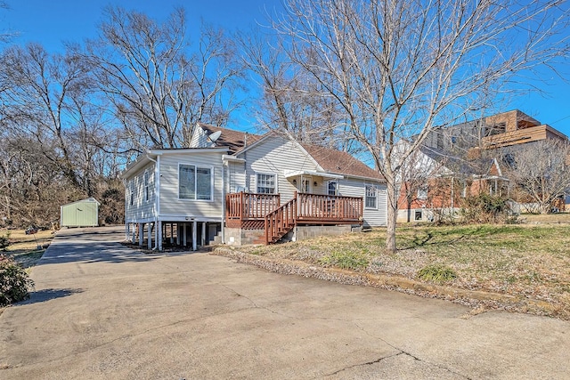 view of front of home featuring a deck, a carport, and a storage unit