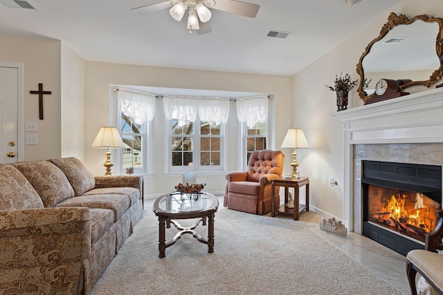 carpeted living room featuring a fireplace and ceiling fan