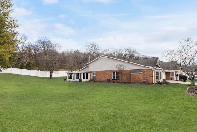 view of side of home featuring central AC and a lawn