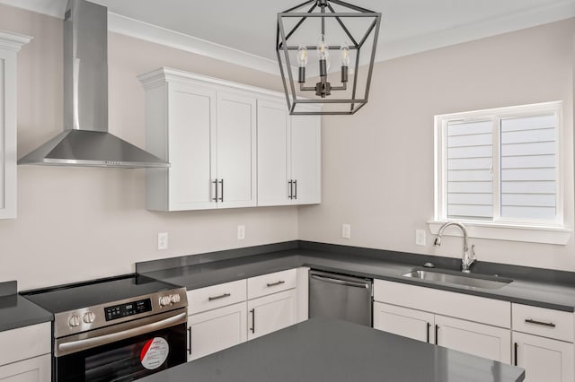 kitchen with sink, white cabinetry, decorative light fixtures, stainless steel appliances, and wall chimney range hood