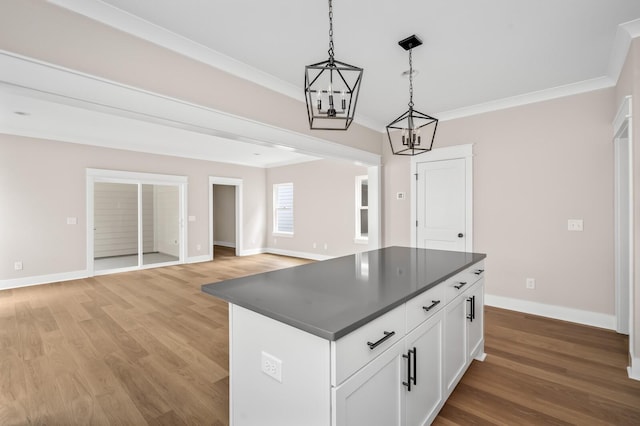 kitchen with white cabinetry, hanging light fixtures, a center island, crown molding, and light hardwood / wood-style flooring