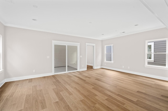 unfurnished room with plenty of natural light, ornamental molding, and light wood-type flooring