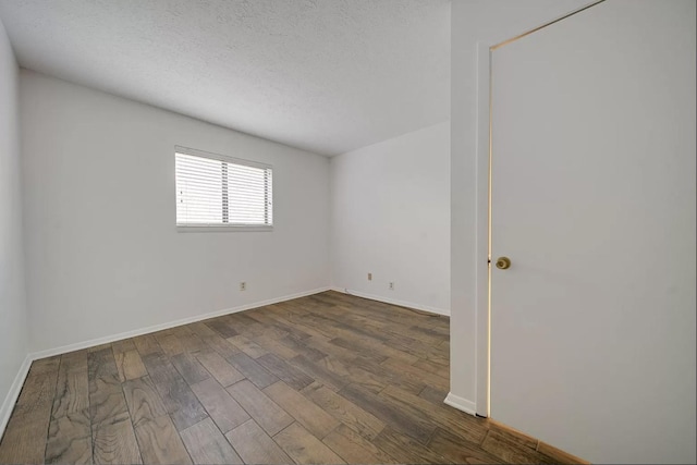 spare room with dark wood-type flooring and a textured ceiling