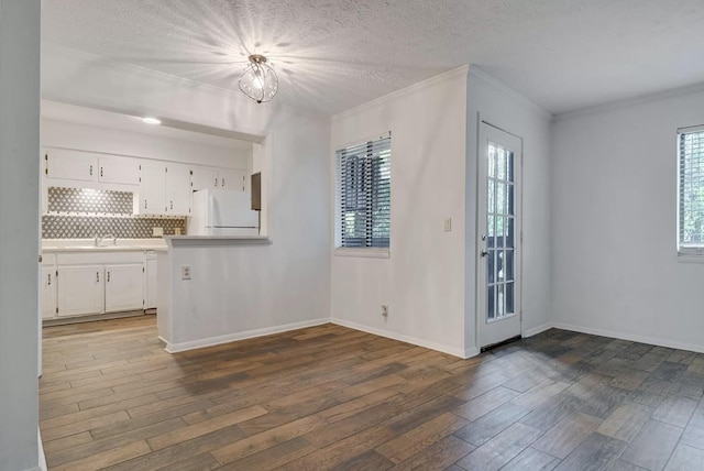 kitchen with white cabinetry, dark hardwood / wood-style floors, and white fridge