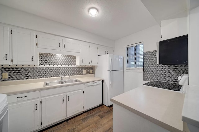 kitchen featuring sink, white appliances, white cabinetry, dark hardwood / wood-style flooring, and decorative backsplash