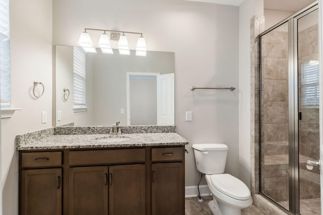 bathroom with vanity, a shower with shower door, and toilet