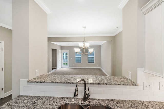 kitchen with crown molding, light stone countertops, and sink