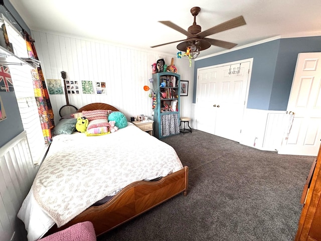 bedroom with dark colored carpet, ornamental molding, ceiling fan, and a closet