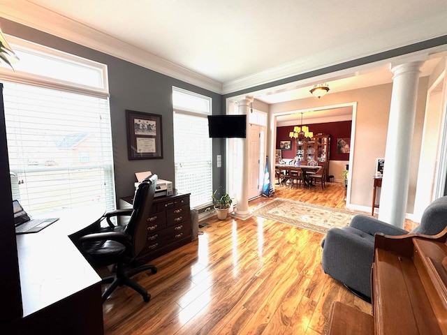 office with a healthy amount of sunlight, light hardwood / wood-style floors, and ornate columns