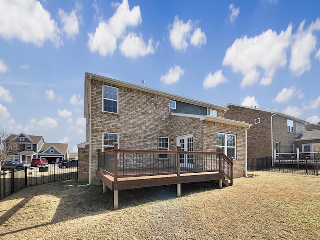 back of property with a wooden deck and a lawn