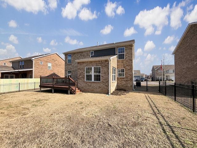 back of property featuring a wooden deck and a yard