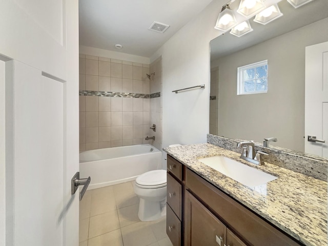 full bathroom featuring tile patterned floors, toilet, tiled shower / bath combo, and vanity