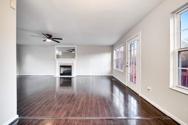 unfurnished living room featuring ceiling fan and dark hardwood / wood-style flooring