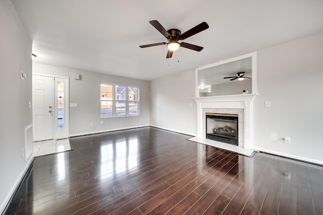 unfurnished living room featuring ceiling fan, a high end fireplace, and dark hardwood / wood-style flooring