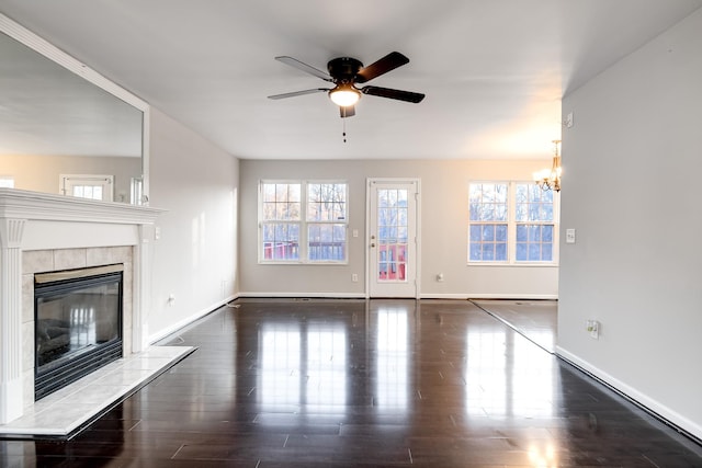 unfurnished living room featuring dark hardwood / wood-style flooring, a healthy amount of sunlight, and a fireplace