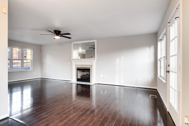 unfurnished living room featuring ceiling fan, dark hardwood / wood-style floors, and a fireplace