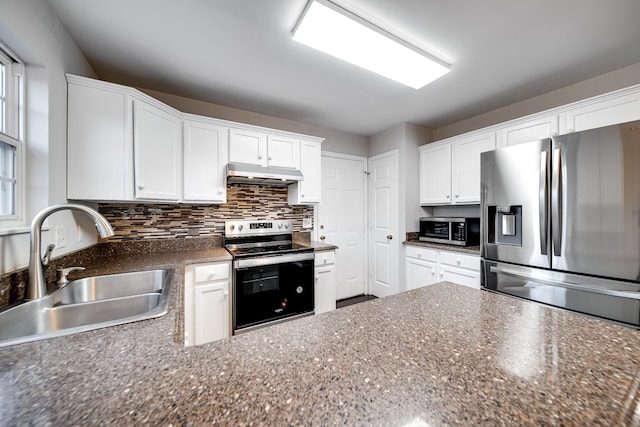 kitchen with sink, dark stone countertops, stainless steel appliances, white cabinets, and decorative backsplash