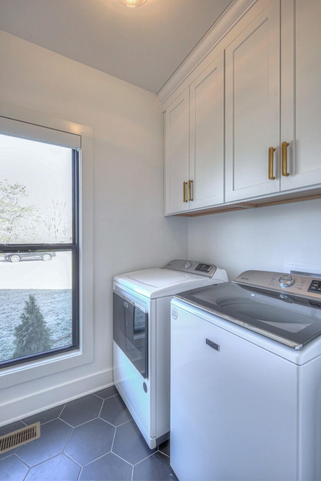 laundry room featuring cabinets and washing machine and dryer