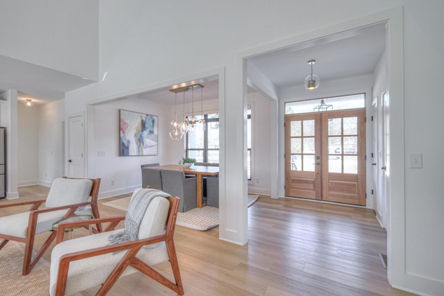 foyer with light hardwood / wood-style flooring, french doors, and plenty of natural light