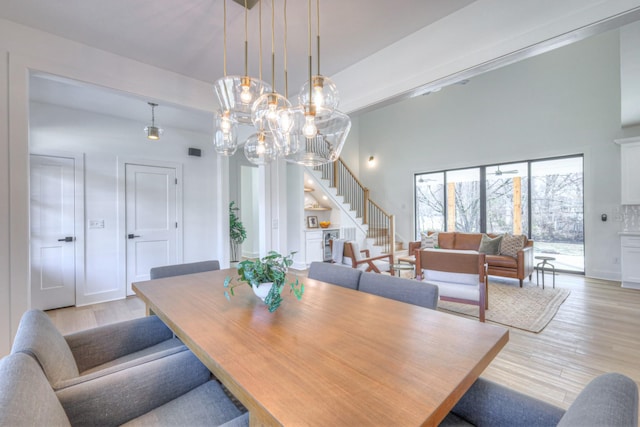 dining area with light hardwood / wood-style flooring and a high ceiling