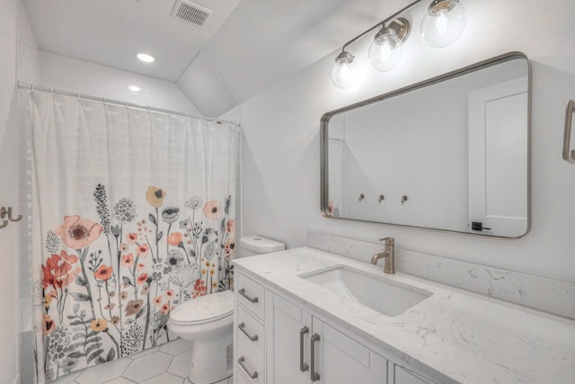 bathroom featuring vanity, vaulted ceiling, tile patterned floors, and toilet