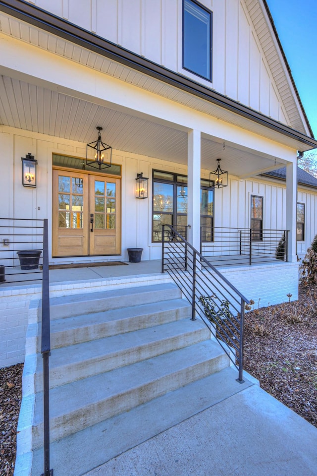 view of exterior entry featuring french doors and a porch