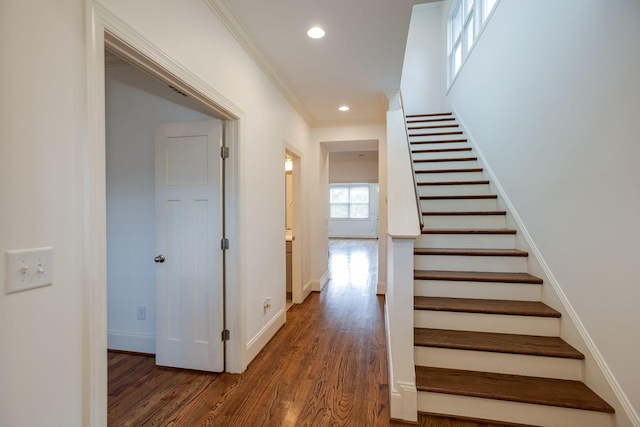 staircase with hardwood / wood-style flooring and ornamental molding