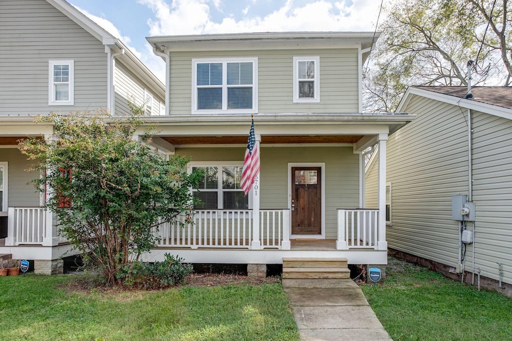 view of front facade featuring covered porch and a front yard