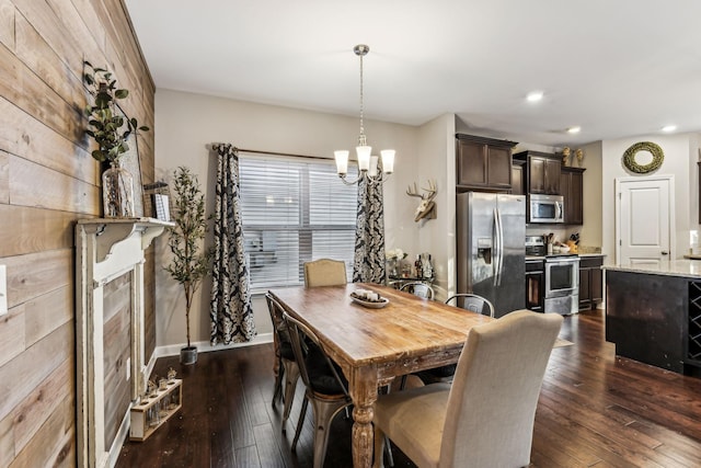 dining area with an inviting chandelier, a tiled fireplace, and dark hardwood / wood-style floors