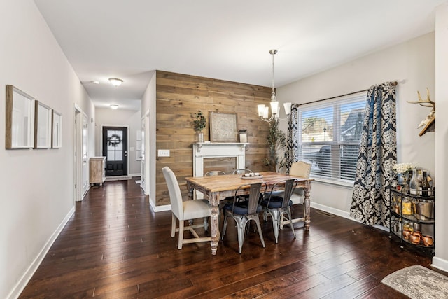 dining room featuring dark hardwood / wood-style floors, an inviting chandelier, and wooden walls